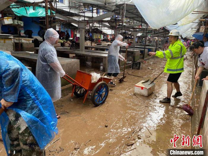 圖為7月26日，暴雨引發(fā)的洪水過(guò)境后，重慶萬(wàn)州區(qū)分水鎮(zhèn)政府干部職工及志愿者清掃淤泥和垃圾?！　≈貞c萬(wàn)州區(qū)委宣傳部供圖 攝