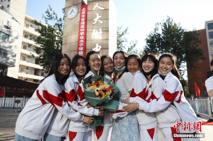 資料圖：6月10日，在北京人大附中高考考點(diǎn)外，考生們相擁拍照留念。當(dāng)日，北京市2021年高考結(jié)束。　 <a target='_blank'  data-cke-saved- ><p  align=