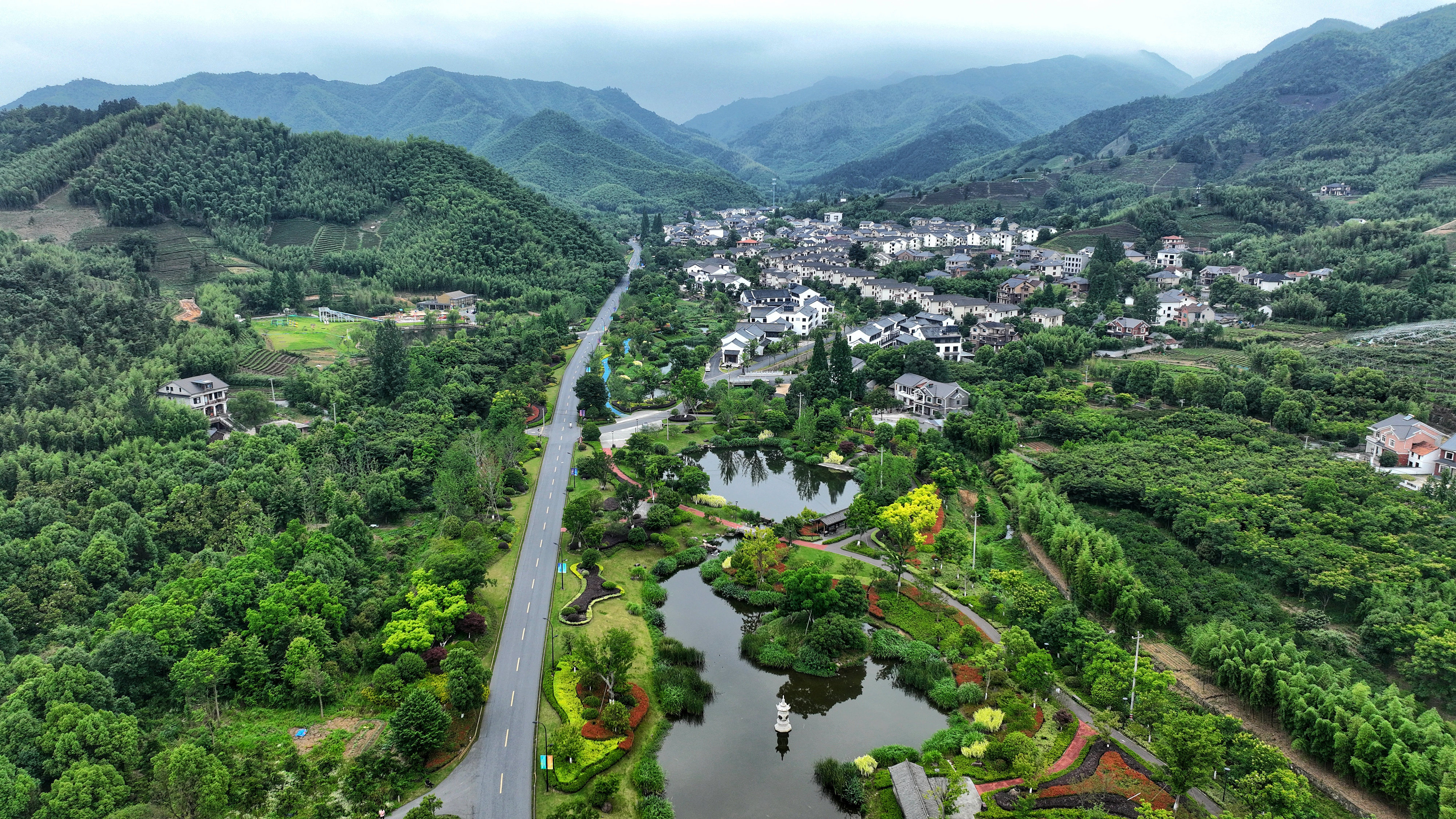 2023年6月6日，杭州余杭區(qū)徑山鎮(zhèn)鄉(xiāng)村，生態(tài)碧水、沿路花海與村莊農(nóng)房相映成趣，構(gòu)成一幅美麗的山水田園畫。